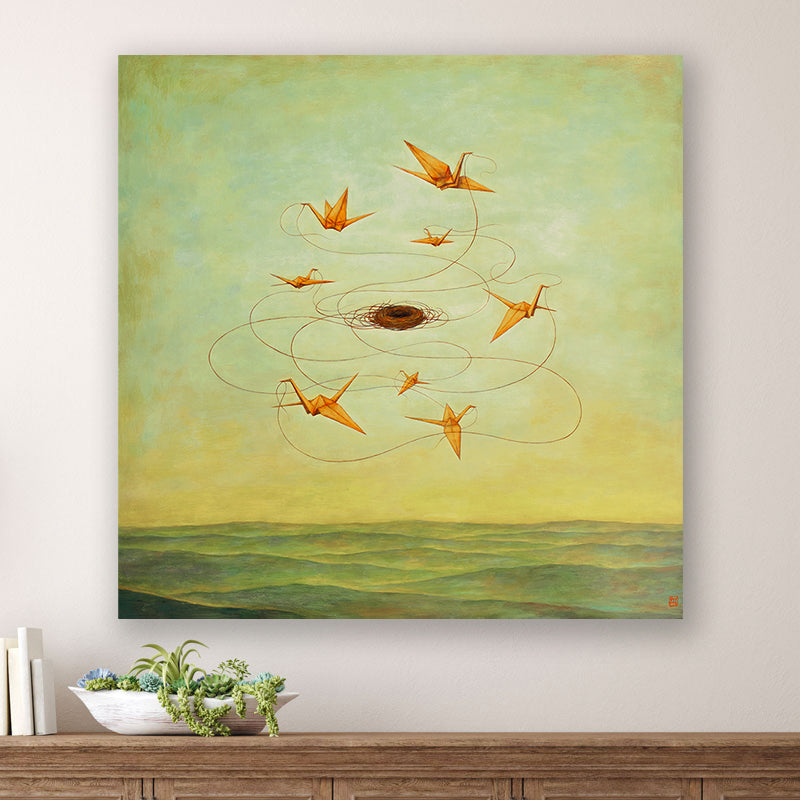 MomentariNest, a 30 x 30" painting by Charlotte NC artist Duy Huynh.  Eight orange origami birds weaving a nest in a greenish yellow sky, over an open landscape. The painting is displayed over a wood console table. 