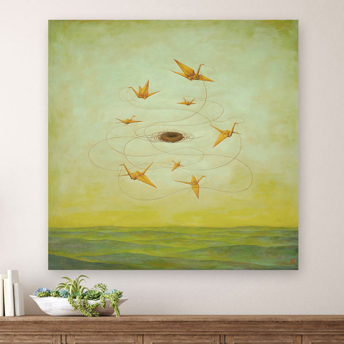 MomentariNest, a 30 x 30" surreal painting by Charlotte NC artist Duy Huynh.  Eight orange origami birds weaving a nest in a greenish yellow sky, over an open landscape. Displayed over wood console table.