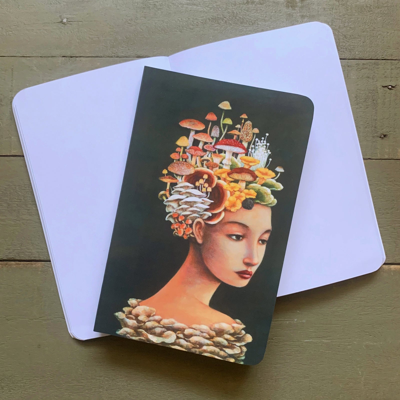 Duy Huynh notebook featuring his "Mycology Mythology" artwork, portrait of a woman with mushrooms growing from her head.
