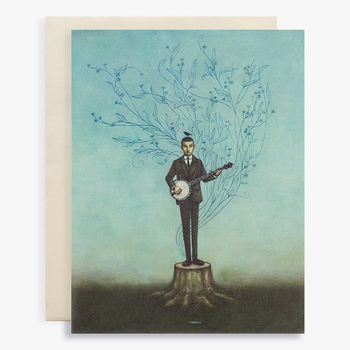 Duy Huynh notecard "Bowerbird Blues". A man stands on the stump of a tree playing a banjo. A bowerbird sits on his head, a blue feather lies on the ground. Card is blank inside.