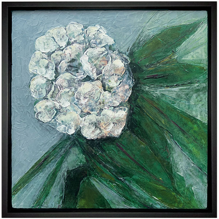 Oil and cold wax painting of a white  flower, green leaves and blue background, framed in black. Artwork by Elizabeth Davant at Lark & Key, Charlotte NC.