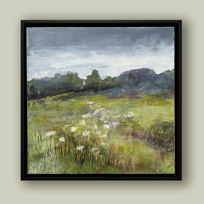 Oil and cold wax painting by North Carolina artist Elizabeth Davant depicting a lush green Blue Ridge Mountain landscape with a field of flowers. Set in a black frame and shown on a pale green wall. 