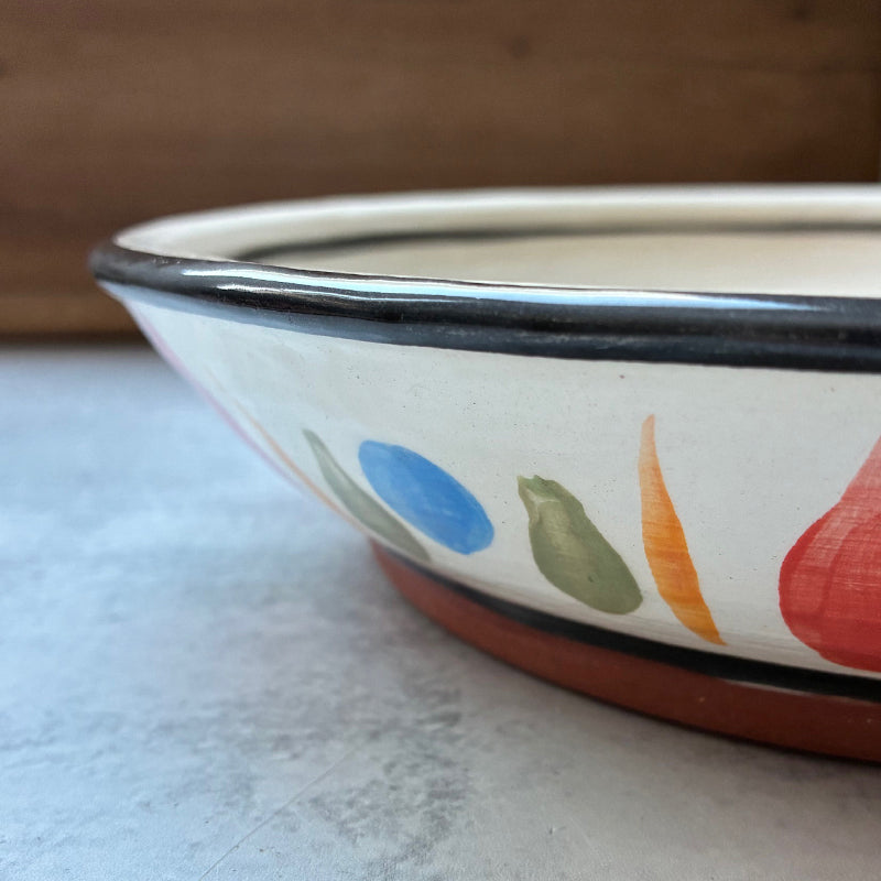 Handmade ceramic serving bowl with apple, pear and grape decoration by Molly Lithgo. Side view.
