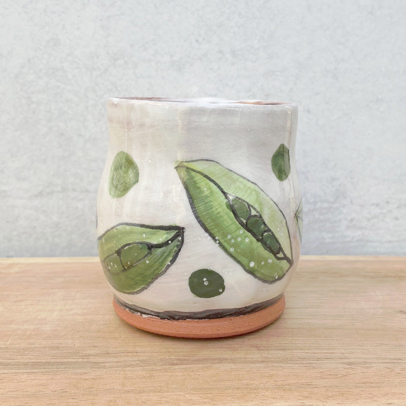 Handmade ceramic mug by NC potter Molly Lithgo. White with green pea pods decoration. View 2.