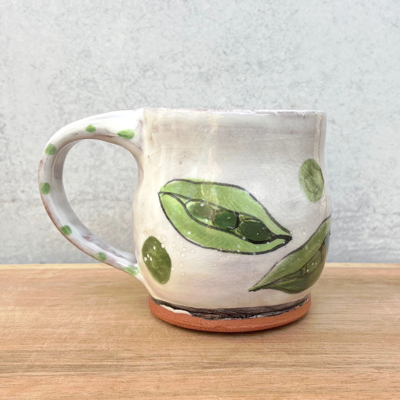 Handmade ceramic mug by NC potter Molly Lithgo. White with green pea pods decoration. 