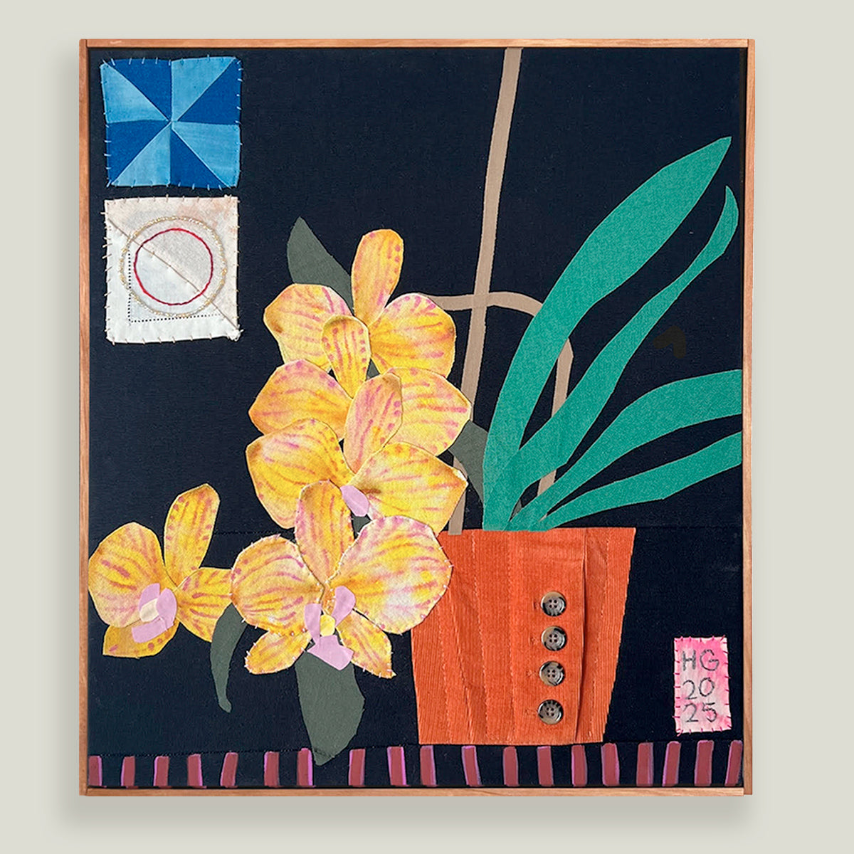 Yellow Orchids, Hannah Goff mixed media textile artwork. Orange flower pot with yellow orchid plant against black background with geometric details.  Displayed on light tan wall. 