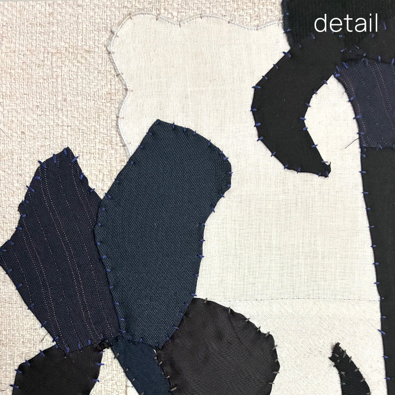 Framed textile artwork of black iris flowers on a textured beige background by Hannah Goff.  Close up detail. 