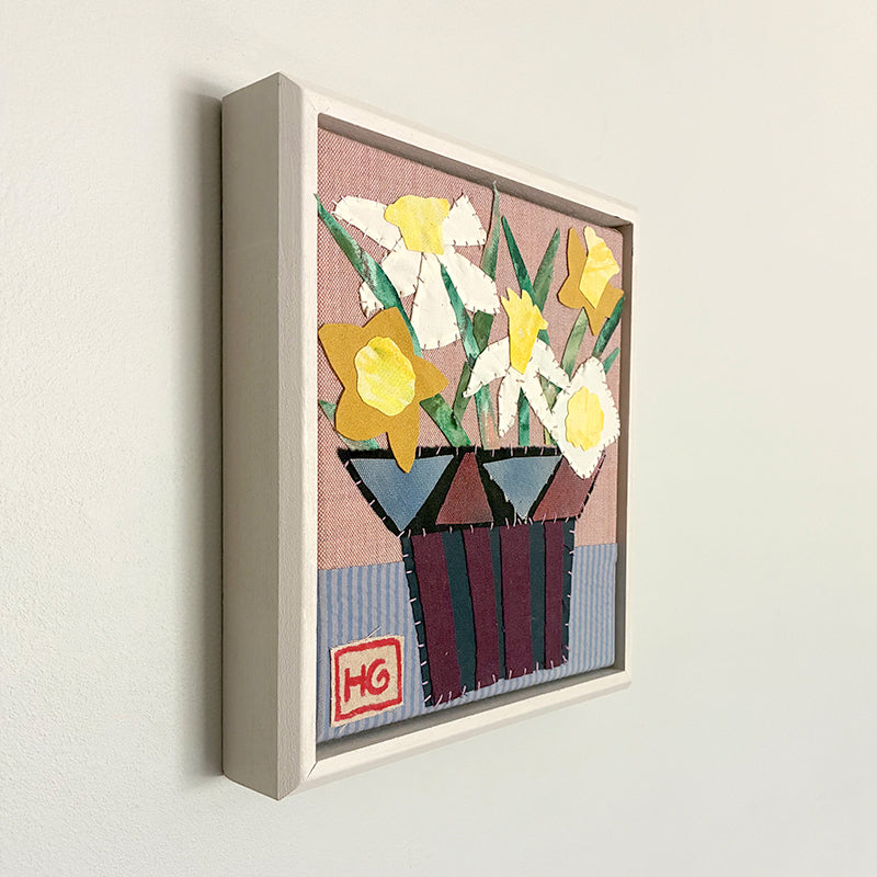 Buttercup Bouquet, framed textile collage by Hannah Goff, yellow daffodils in vase. Side view on wall.