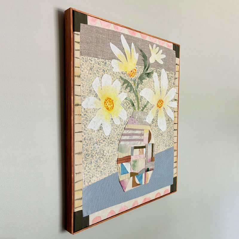Patchwork Daisies by Hannah Goff, mixed media textile artwork with patchwork vase and white daisies. Side view on wall. 
