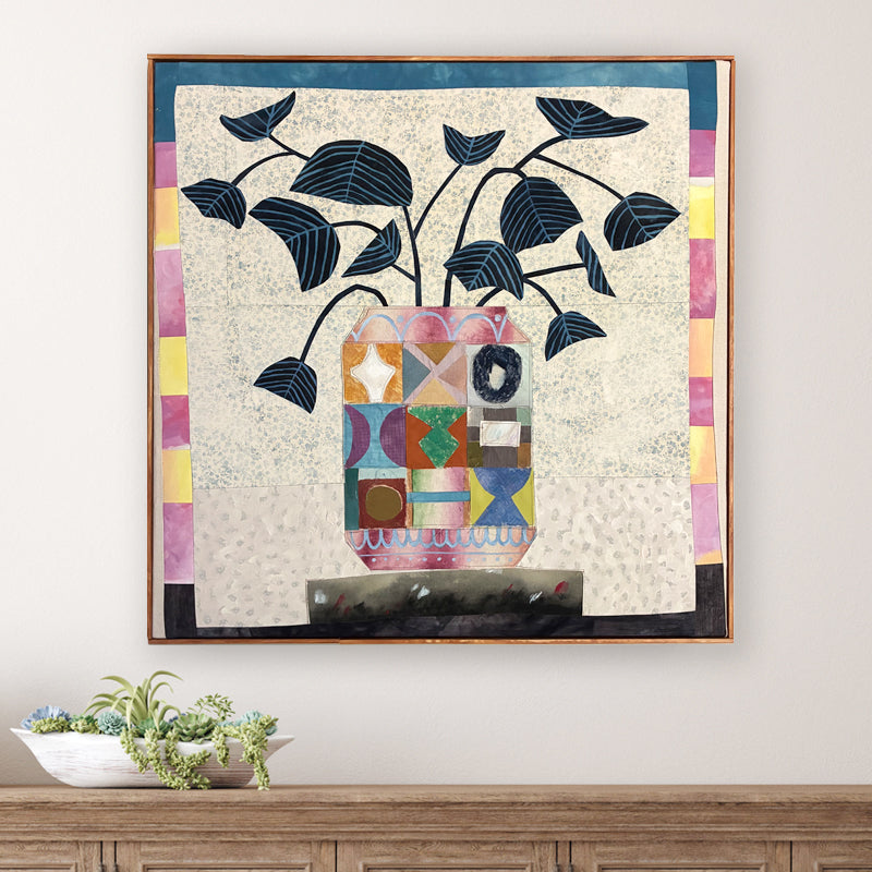 Multi Patchwork Vase artwork by Hannah Goff, colorful, contemporary quilted mixed media vase with abstracted flowers and wood frame. Displayed over table. 