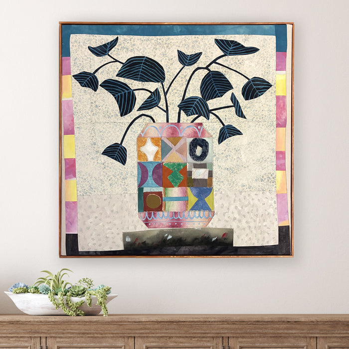 Multi Patchwork Vase artwork by Hannah Goff, colorful, contemporary quilted mixed media vase with abstracted flowers and wood frame. Displayed over table. 