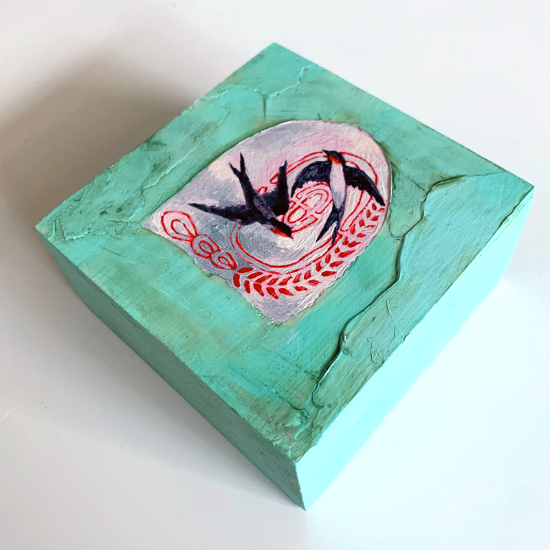 Swallows and Labyrinth, a small mixed media painting by artist Hannah Seng. Two swallow in a portal surrounded by textured aqua paint. View 2.