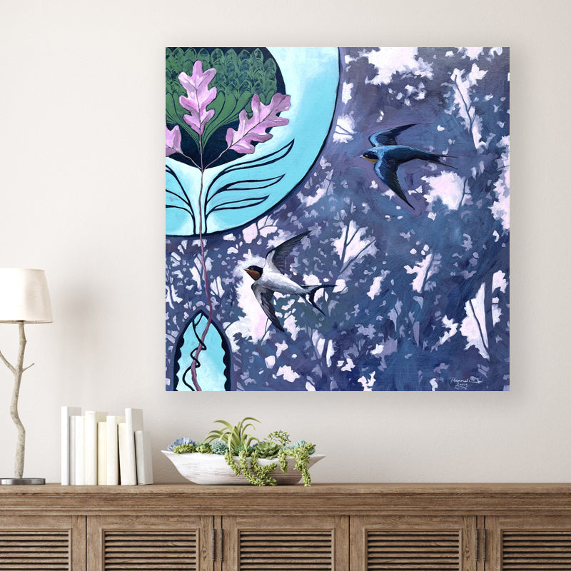 "The Dawn Upon the Oaks" artwork by Western NC based artist Hannah Seng. The nature inspired painting -  in blues, purples and green - features two barn swallows flying among oak tree leaves, and an art nouveau illustration detail. Shown on white wall.