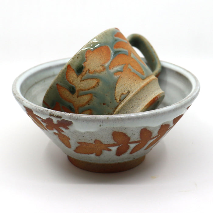 Handmade wood-fired mug and bowl with botanical design by Heather Ossandon.