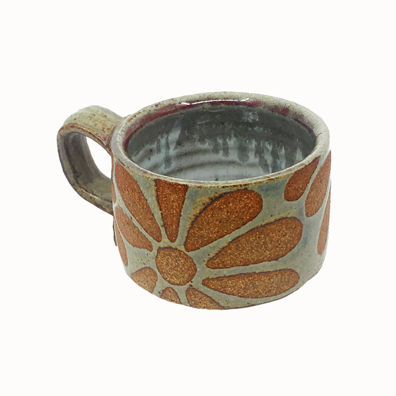 Woodfired creamic mug by Heather Ossandon, earthy hues with rust flower pattern. Angled view.