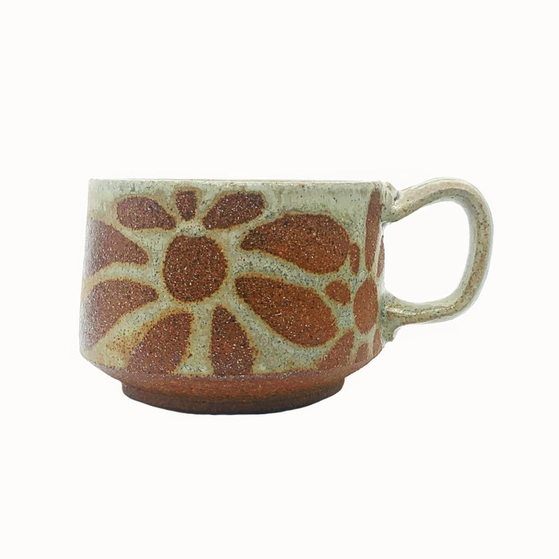 Heather Ossandon handmade, woodfired mug, side view. Creamy hues with rust flower pattern.