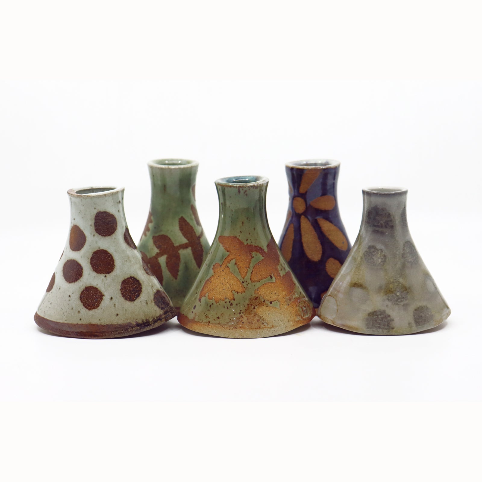 Wood fired ceramic bud vases in various colors and patterns.