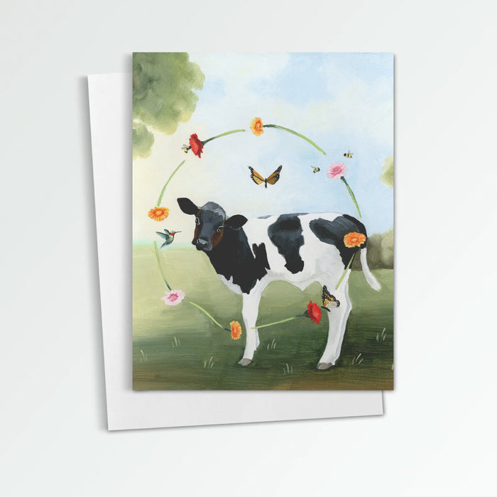 Farm Sweet Farm Cow notecard from Kim Ferreira. A black and white cow is surrounded by a circle of flowers, a hummingbird, bees and butterflies.