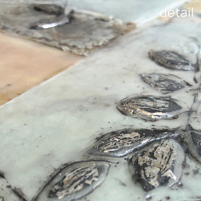 Mixed media encaustic artwork from Liberty Hanson-Wild's series called Yesterday's Seeds.  An abstracted background in neutral colors with textures and leaf pattern with silver.  Close up detail. 