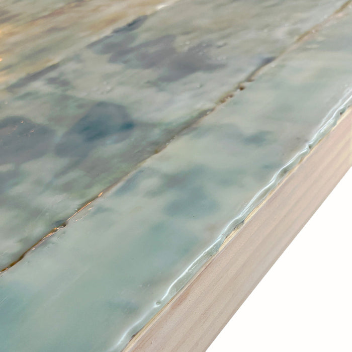 Mixed media encaustic artwork on panel, soft neutral tones in grid pattern with leaves and silver detail. Close up side detail. 
