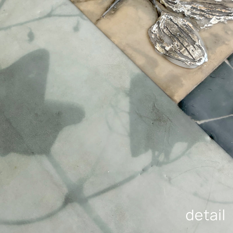 Close up detail of mixed media encaustic artwork with silver leaf detail. 