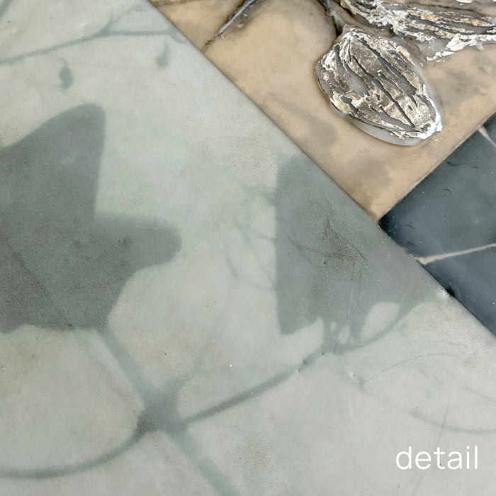 Close up detail of mixed media encaustic artwork with silver leaf detail. 