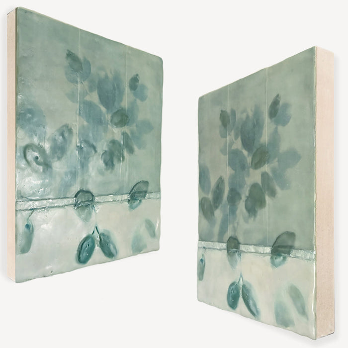 Mixed media encaustic artwork with creamy white and pale green leaf pattern. Angled views.