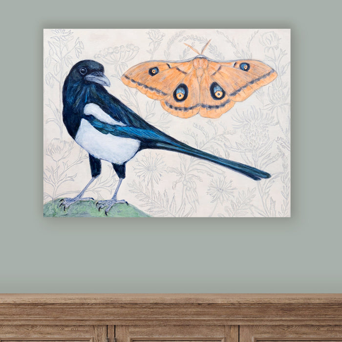 Magpie Dreams by artist Martha Worthy. Painting of a magpie bird and a Polyphemus moth, with a subtle, botanical background on light green wall.