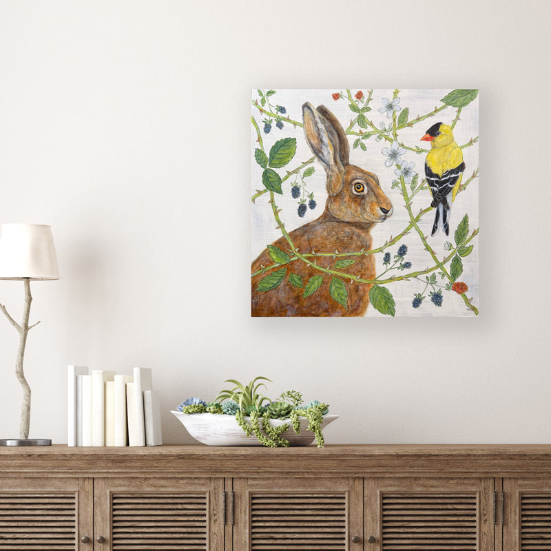 "The Briar Patch" artwork by Martha Worthy. The nature inspired acrylic painting features a rabbit and a goldfinch in a briar patch. Painting shown on white wall.