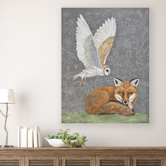 "Whispering Wisdom" acrylic painting by artist Martha Worthy. Nature inspired artwork with a barn owl in flight and a fox resting the ground, botanical details in the background. Shown on white wall.