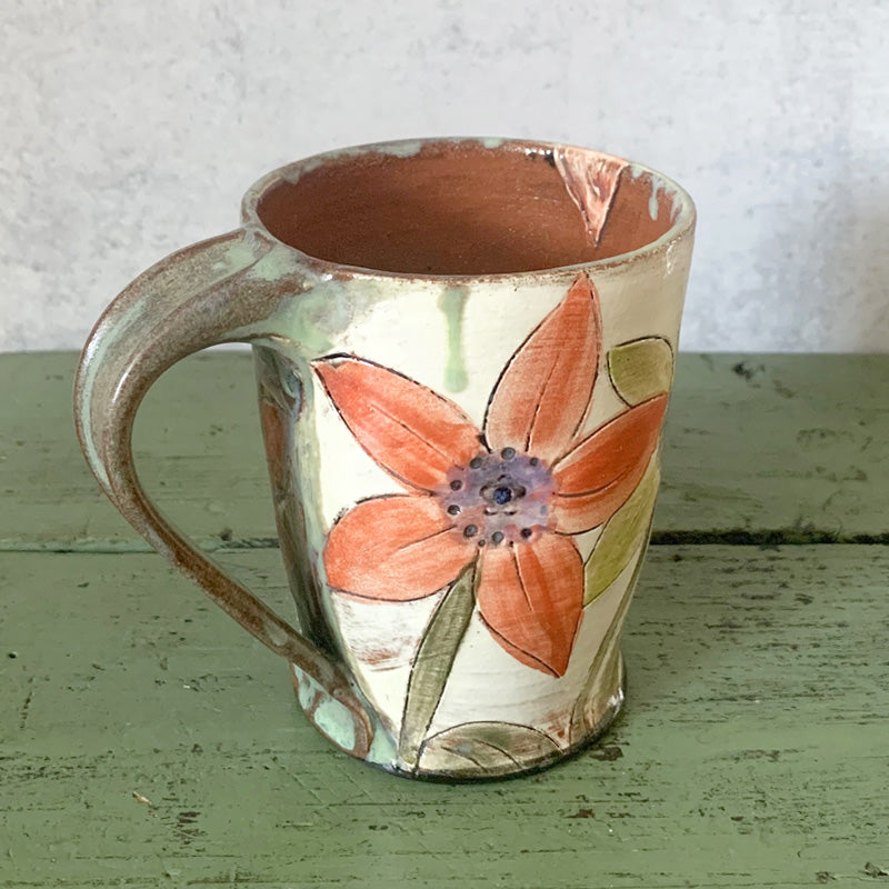 Handmade ceramic mug with yellow and orange flower decoration by Molly Lithgo. Made in North Carolina. View 2.