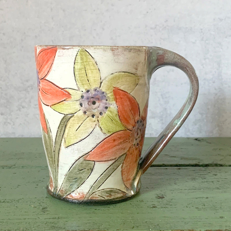 Handmade ceramic mug with yellow and orange flower decoration by Molly Lithgo. Made in North Carolina. 