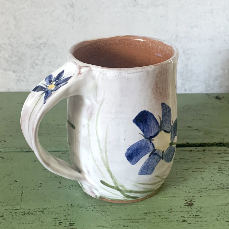 Handmade ceramic mug with hand painted blue flower decoration by Molly Lithgo. Made in North Carolina. View 2.
