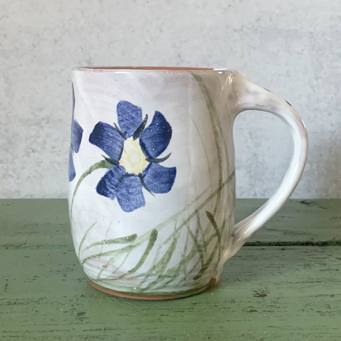Handmade ceramic mug with hand painted blue flower decoration by Molly Lithgo. Made in North Carolina. 