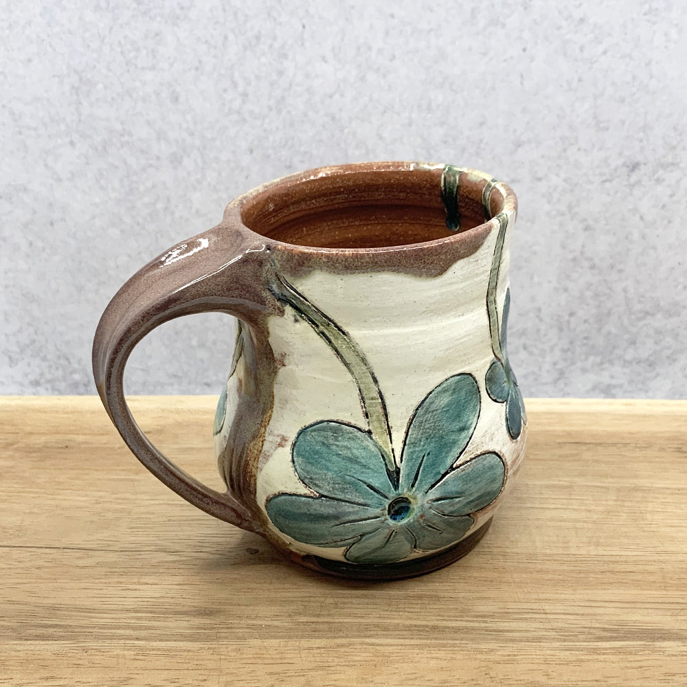 Handmade ceramic mug with flower decoration by Molly Lithgo. Made in North Carolina.