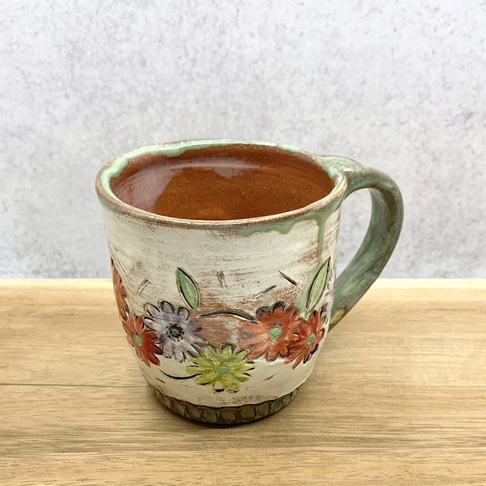 Handmade ceramic mug with flower decoration by Molly Lithgo. Made in North Carolina.