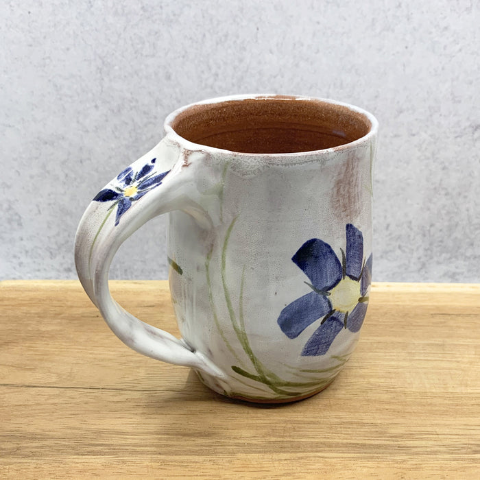 Handmade ceramic mug with flower decoration by Molly Lithgo. Made in North Carolina.