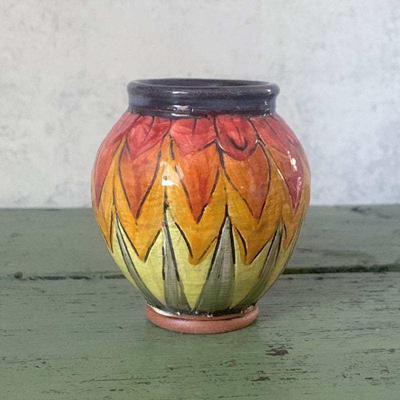 Mini handmade bud vase with orange, yellow and green leaf design by Molly Lithgo. Made in NC.