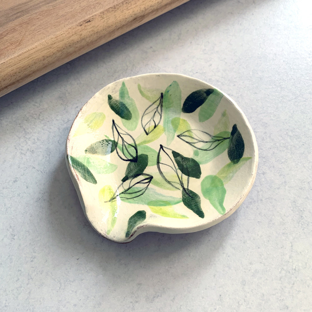 Handmade ceramic spoon rest by Molly Lithgo, decorated with various green leaves. Made in North Carolina.