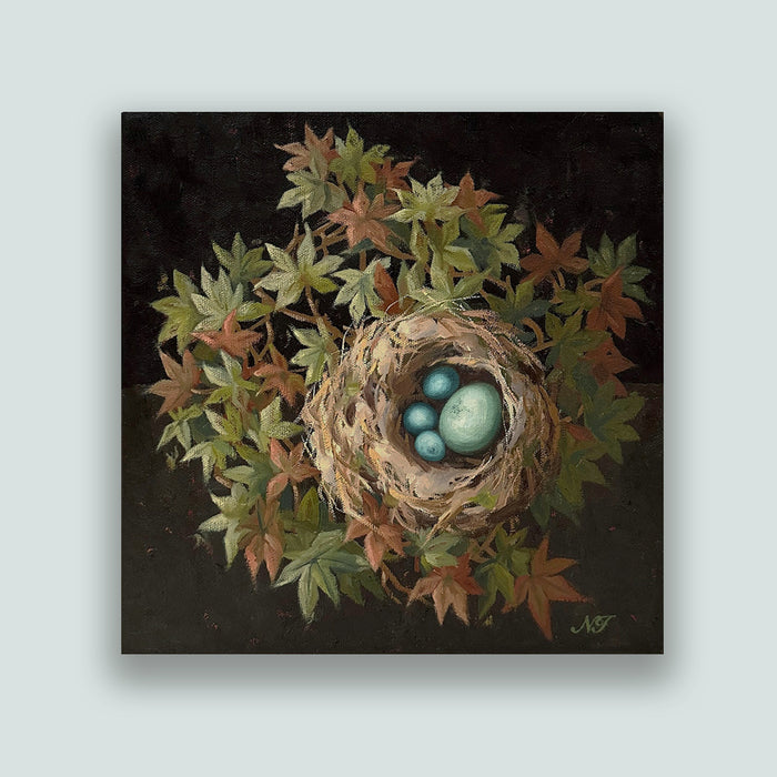 "The Four of Us", 10 x 10" oil painting by Ninalee Irani. A nest with four blue eggs is nestled among green and rust colored foliage, with a dark background. Artwork shown on pale blue wall. 