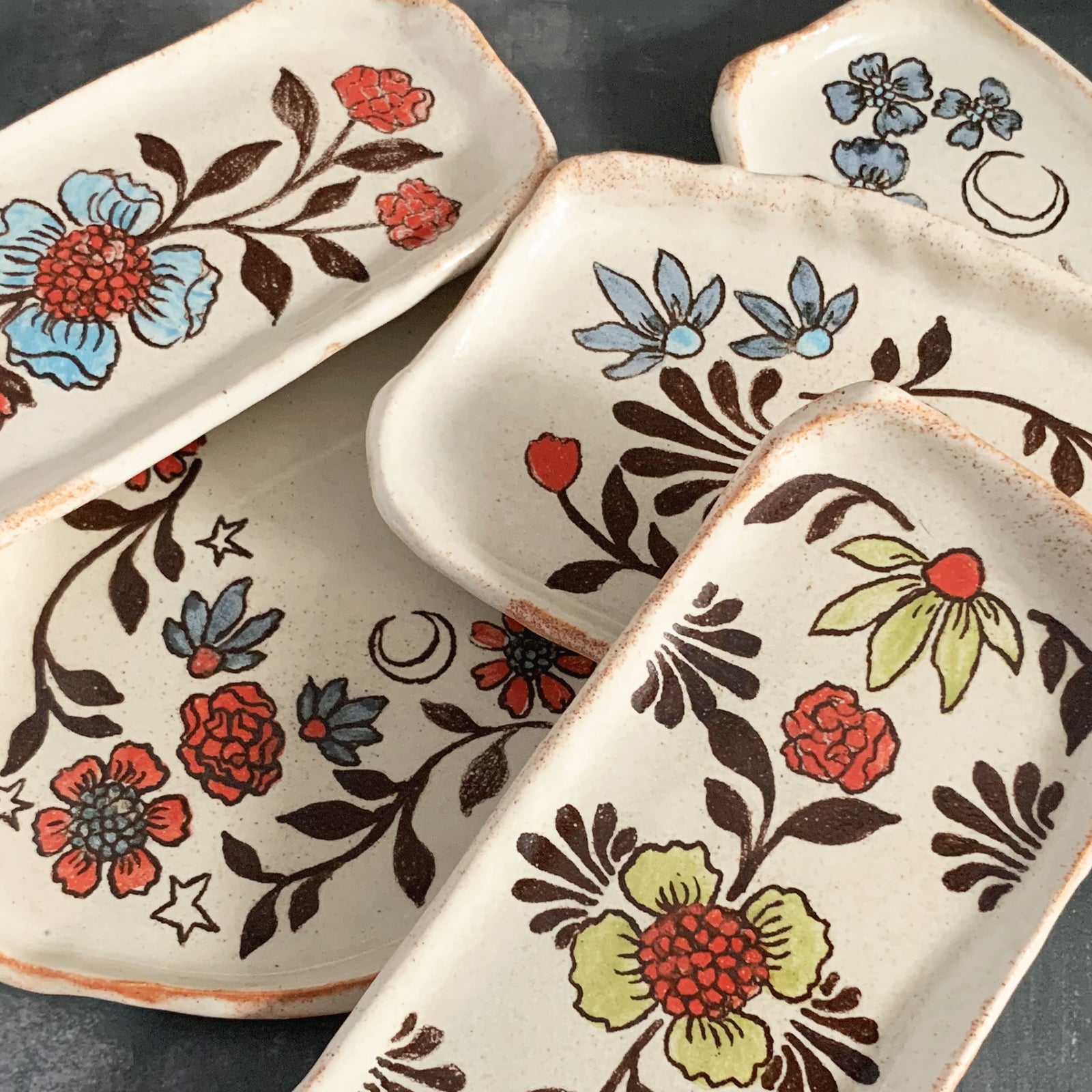 Handmade pottery from Off Menu Pots. Small dishes decorated with flower and moon designs. 