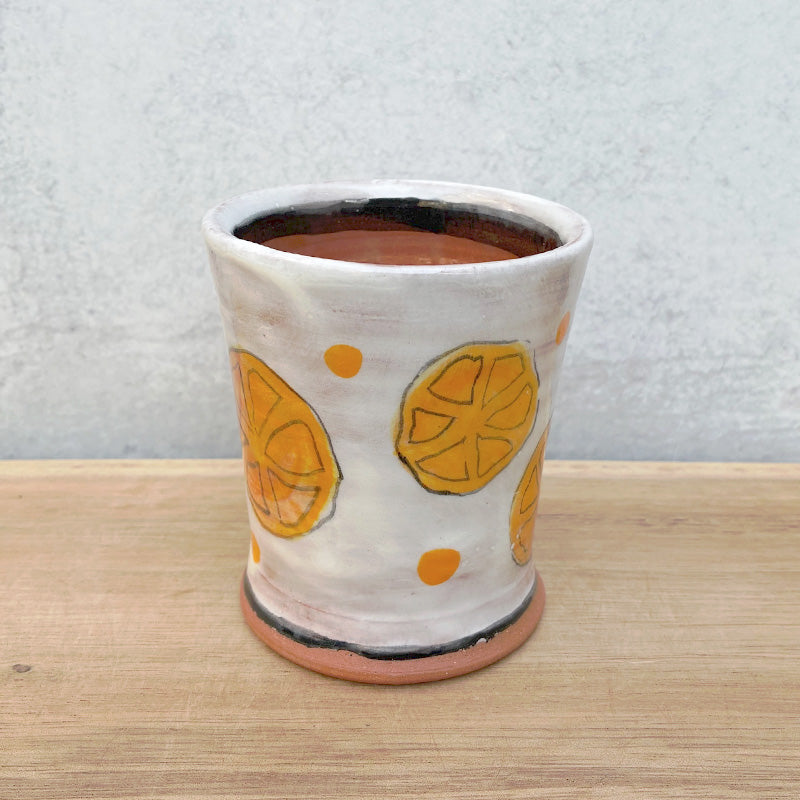 Handmade ceramic cup by NC potter Molly Lithgo. White with orange slice and polka dot decoration.  Alternate view. 