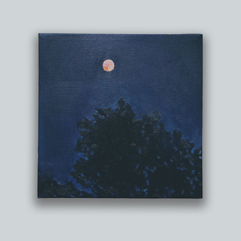 An oil painting, by Bridgette Guerzon Mills, depicting a dark blue night sky with al small orange moon just above the silhouette of treetops. Shown on pale gray wall.