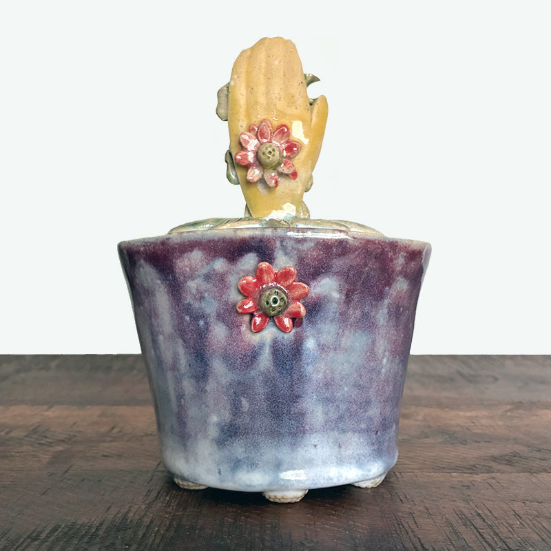 Purple handmade ceramic lidded jar with hand, rooster and flower details. 