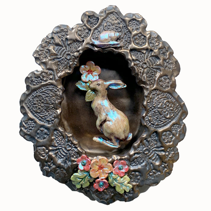 Rabbit and snail ceramic wall niche by Paula Smith. Decorative wall art featuring a rabbit, snail and flowers. 