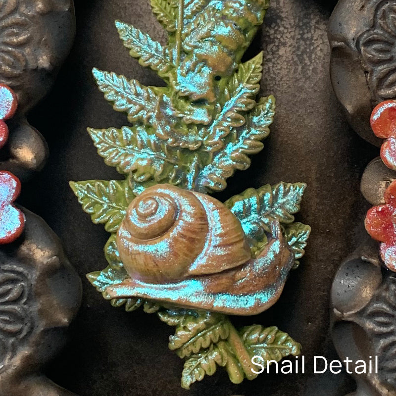 Snail ceramic wall niche by Paula Smith. Decorative wall art featuring a snail, fern and flowers.  Snail detail.