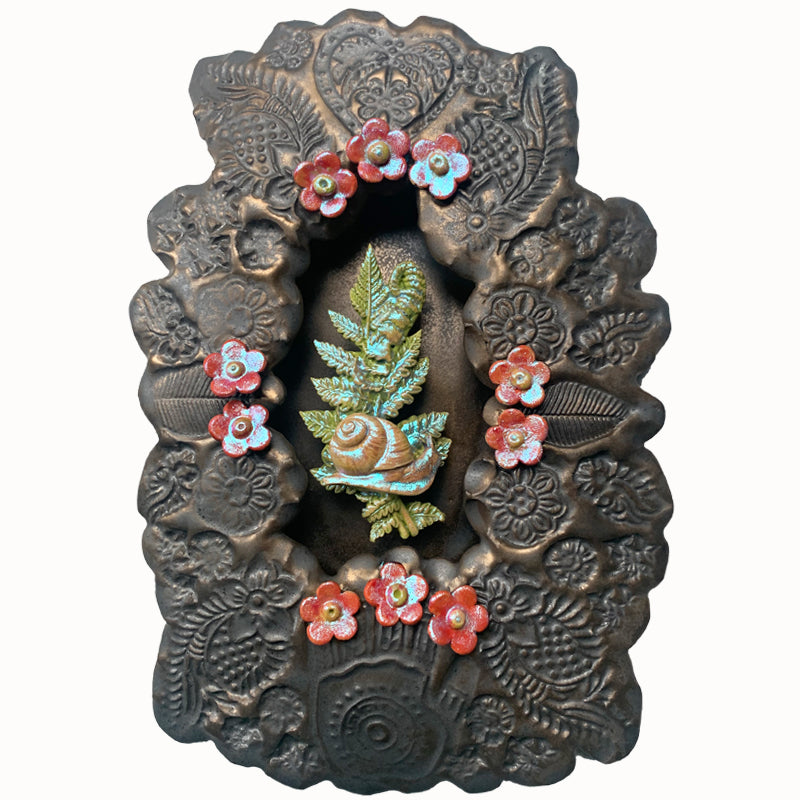 Snail ceramic wall niche by Paula Smith. Decorative wall art featuring a snail, fern and flowers. 