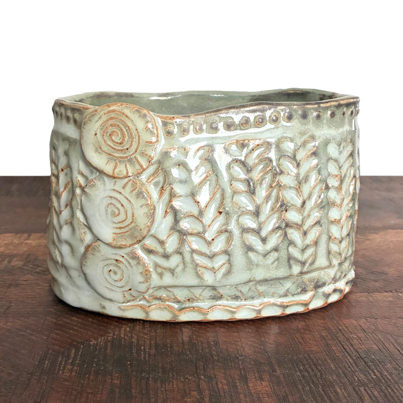 Handmade ceramic oval container with texture details. 