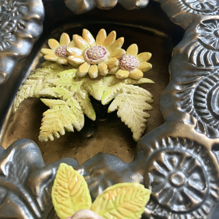 Handmade ceramic wall niche with flower details by Paula Smith. Gunmetal glazed clay with stamped details, with three dimensional yellow flowers and leaves. Interior flower detail.