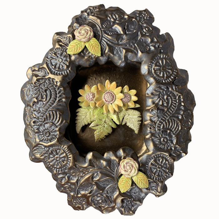 Handmade ceramic wall niche with flower details by Paula Smith. Gunmetal glazed clay with stamped details, with three dimensional yellow flowers and leaves.